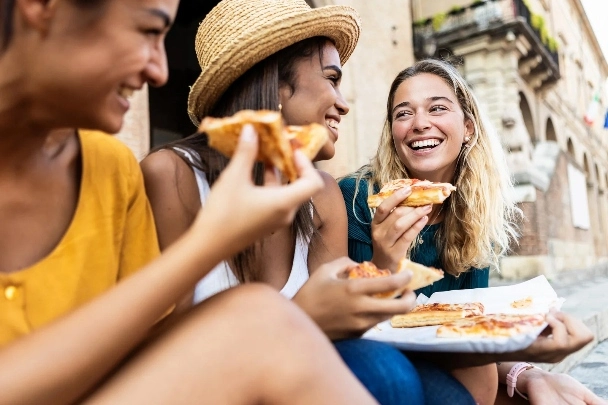 happy female friends enjoying holidays together in Italy